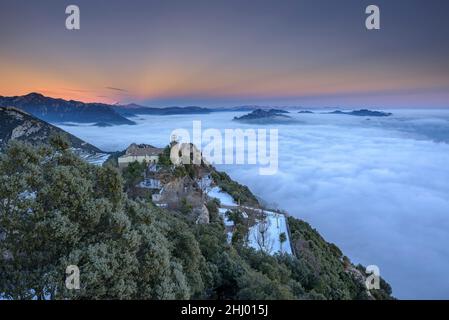 Sanctuaire de Queralt au coucher du soleil d'hiver avec une mer de nuages au-dessus de Berga (Berguedà, Catalogne, Espagne, Pyrénées) ESP: Santuario de Queralt al atardecer Banque D'Images