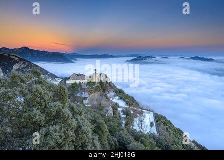 Sanctuaire de Queralt au coucher du soleil d'hiver avec une mer de nuages au-dessus de Berga (Berguedà, Catalogne, Espagne, Pyrénées) ESP: Santuario de Queralt al atardecer Banque D'Images
