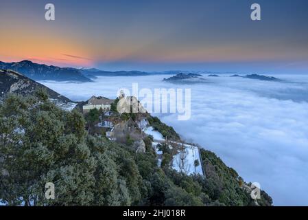 Sanctuaire de Queralt au coucher du soleil d'hiver avec une mer de nuages au-dessus de Berga (Berguedà, Catalogne, Espagne, Pyrénées) ESP: Santuario de Queralt al atardecer Banque D'Images
