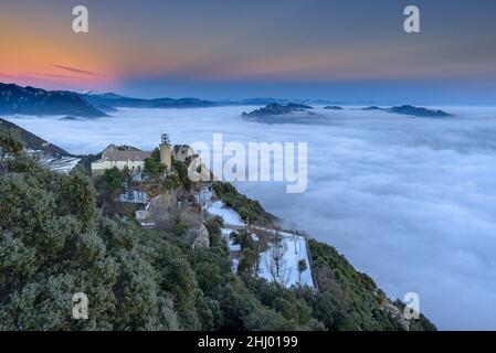 Sanctuaire de Queralt au coucher du soleil d'hiver avec une mer de nuages au-dessus de Berga (Berguedà, Catalogne, Espagne, Pyrénées) ESP: Santuario de Queralt al atardecer Banque D'Images