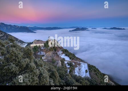 Sanctuaire de Queralt au coucher du soleil d'hiver avec une mer de nuages au-dessus de Berga (Berguedà, Catalogne, Espagne, Pyrénées) ESP: Santuario de Queralt al atardecer Banque D'Images