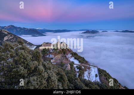 Sanctuaire de Queralt au coucher du soleil d'hiver avec une mer de nuages au-dessus de Berga (Berguedà, Catalogne, Espagne, Pyrénées) ESP: Santuario de Queralt al atardecer Banque D'Images
