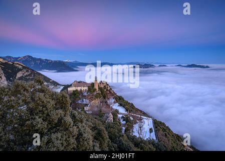 Sanctuaire de Queralt au coucher du soleil d'hiver avec une mer de nuages au-dessus de Berga (Berguedà, Catalogne, Espagne, Pyrénées) ESP: Santuario de Queralt al atardecer Banque D'Images