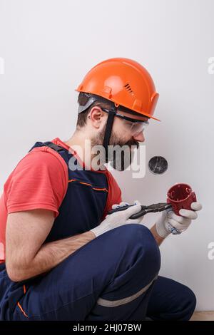 l'électricien installe les prises du casque Banque D'Images