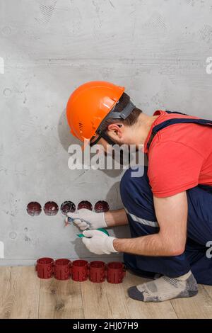 l'électricien installe les prises du casque Banque D'Images