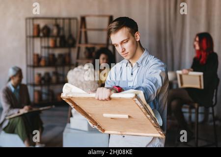 Jeune étudiant blanc homme dessin buste en plâtre pendant la classe dans l'école d'art à l'intérieur Banque D'Images