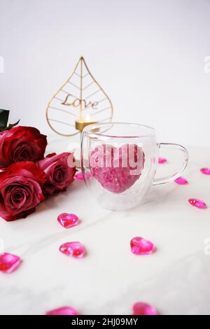 Cacao bon en forme de coeur rose.Ajoutez du lait chaud pour une boisson au cacao sucré.Concept de la date et de la Saint-Valentin.Photo verticale Banque D'Images