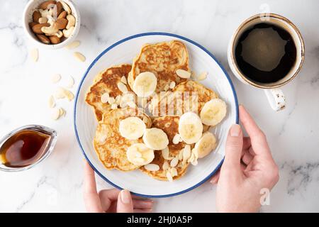 Pancakes à la banane végétalienne avec noix et une tasse de boisson à la chicorée noire.Vue de dessus.Un petit déjeuner sain et propre concept de dieting Banque D'Images