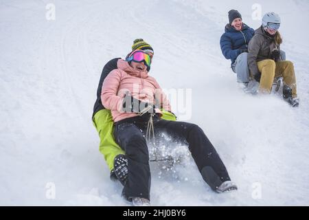 Fou heureux amis s'amuser avec la luge sur la neige hautes montagnes - Focus sur la fille droite Banque D'Images