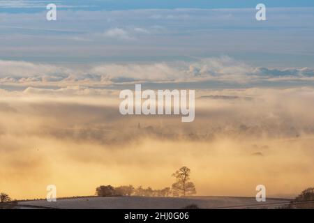 La flèche de l'église All Saints Church, l'église paroissiale de Burton à Lonsdale, dans le North Yorkshire, s'élance au-dessus d'une spectaculaire inversion de nuages à la fin de l'af Banque D'Images