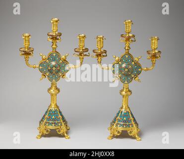 Paire de candelabra ca.1865–70 firme de Ferdinand Barbedienne la décoration a été inspirée par des motifs de la métallurgie romane, mais le design mélange librement une variété de motifs révélateurs de leur origine au XIXe siècle.Barbédienne était l'une des plus grandes fonderies de France dans la seconde moitié du XIXe siècle, et ses objets émaillés ont été revendiqués lors de l'exposition internationale de Londres en 1862.Paire de candélabres.Français, Paris. CA.1865–70.Laiton doré, émail cloisonné.Travail des métaux - laiton Banque D'Images