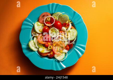 Goiania, Goias, Brésil – 25 janvier 2021 : assiette de salade de légumes sur fond orange. Banque D'Images