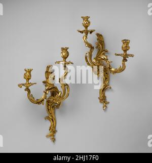 Paire de supports muraux à deux lumières ca.1750 Français la préférence du Rococo pour le tourbillonnage continu et les lignes curvilignes est bien exprimée dans la forme de ces sconces de mur dont il existe un certain nombre de modèles étroitement liés.Les flammes scintillantes des bougies auraient amélioré le sens du mouvement.Paire de supports muraux à deux lumières.Français ca.1750. Bronze doré.Métal-bronze doré Banque D'Images