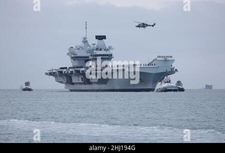 Un hélicoptère Wildcat de la Marine royale passe au-dessus du porte-avions HMS QUEEN ELIZABETH alors que le navire retourne à la base navale après 7 mois Banque D'Images