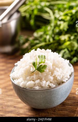 Riz cuit dans un bol avec persil frais. Banque D'Images