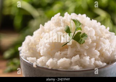 Riz cuit dans un bol avec persil frais - gros plan. Banque D'Images
