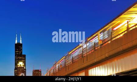 Chicago, Illinois, États-Unis le train de transit rapide CTA Red Line arrivant à Chinatown de Chicago s'arrête sur le côté sud de la ville à mesure que la nuit tombe sur la ville. Banque D'Images