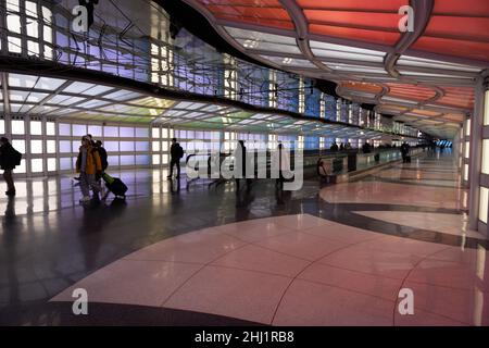 Les passagers de l'air, des gens d'affaires de la marche, de néons colorés art installation par Michael Hayden, tunnel pour piétons, Chicago O'Hare Airport Terminal. Banque D'Images