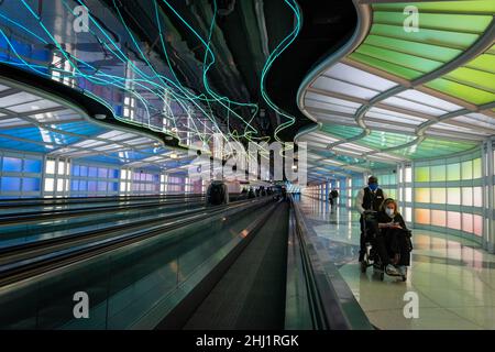 Les passagers de l'air, des gens d'affaires de la marche, de néons colorés art installation par Michael Hayden, tunnel pour piétons, Chicago O'Hare Airport Terminal. Banque D'Images