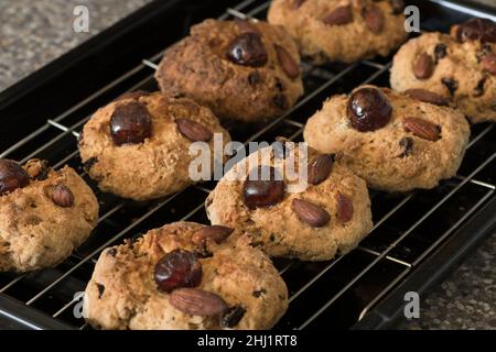 Des rangées nettes de scones faits maison graissent des rascades refroidissant sur le rack Banque D'Images