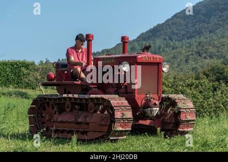 Un garçon italien conduit un ancien tracteur Bubba Ariete Banque D'Images