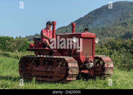 Un garçon italien conduit un ancien tracteur Bubba Ariete Banque D'Images