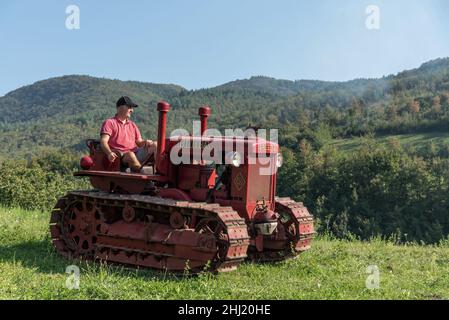 Un garçon italien conduit un ancien tracteur Bubba Ariete Banque D'Images