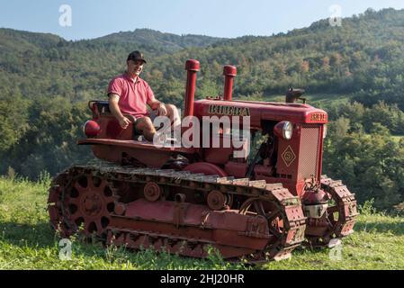 Un garçon italien conduit un ancien tracteur Bubba Ariete Banque D'Images