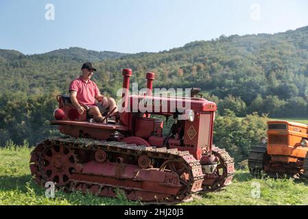 Un garçon italien conduit un ancien tracteur Bubba Ariete Banque D'Images