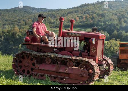 Un garçon italien conduit un ancien tracteur Bubba Ariete Banque D'Images