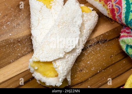 Goiania, Goias, Brésil – 26 janvier 2021 : deux tapiocas farcis de fromage sur un panneau en bois avec un détail en tissu à motifs. Banque D'Images