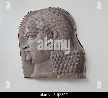 Tête d'un gardien royal sans barbe, peut-être un eunuch ca.721–705 av. J.-C. Assyrien peu après avoir pris le trône, le roi assyrien Sargon II (r.721–705 av. J.-C.) fonda une nouvelle capitale, Dur-Sharrukin (littéralement « forteresse de Sargon »), sur un site connu aujourd'hui sous le nom de Khorsabad.Sargon prit le trône en putsch contre son frère, Shalmaneser V (r.De 726 à 722 av. J.-C.), et il est possible qu'en déménadant dans une nouvelle capitale, il espère consolider son régime.Le nom Sargon, qui signifie « vrai roi », était un nom de trône, et faisait référence à un roi très ancien, Sargon d'Akkad, qui, par la période néo-assyrienne, était rappelé Banque D'Images