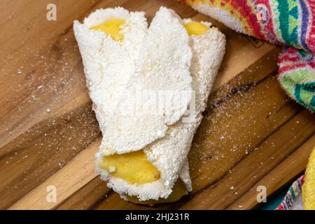 Goiania, Goias, Brésil – 26 janvier 2021 : deux tapiocas farcis de fromage sur un panneau en bois avec un détail en tissu à motifs. Banque D'Images