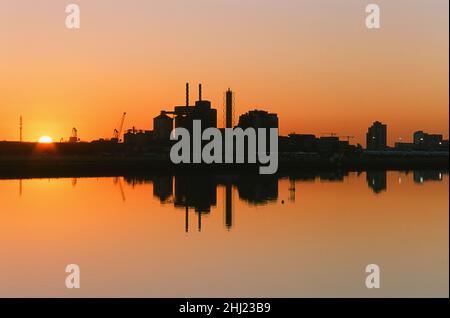 Royal Albert Dock, est de Londres Royaume-Uni, au coucher du soleil, avec l'aéroport de London City et l'usine de Tate & Lyle reflétés dans l'eau. Banque D'Images