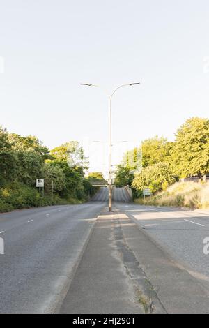 Waterloo Way passant sous le passage inférieur du milieu de New Walk.Arbres à gauche et à droite, avec grand feu de rue au milieu. Banque D'Images