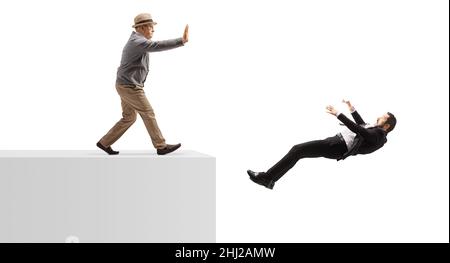 Photo pleine longueur d'un homme âgé poussant un homme d'affaires d'un mur isolé sur fond blanc Banque D'Images