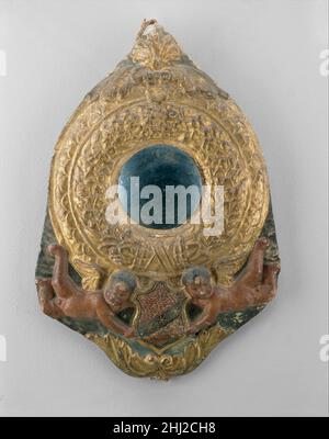 Cadre du rétroviseur Tondo ca.1480 peut-être atelier de Benedetto da Maiano Italien Round, ou tondo, cadres contenant des miroirs ou des images de dévotion étaient un type populaire de mobilier domestique en Toscane dans les XVe et XVIe siècles.Le verre convexe de ce miroir est original et est caractéristique des miroirs du XVe siècle dans toute l'Europe.Le cadre de relief peu profond a été fait en pressant le stuc dans un moule, une technique communément rencontrée dans la sculpture et la décoration architecturale à partir de la fin du Moyen-âge.Ni le bouclier tenu par les deux putti au fond du cadre ni le m Banque D'Images
