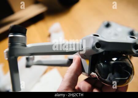 Paris, France - 14 janvier 2022 : la main mâle POV tient le nouveau drone DJI Air 2s avec un accent sur l'inscription du logotype sur le bras arrière droit de ADS-B surveillance-Broadcast automatique dépendante qui utilise des signaux satellites et radio pour identifier les emplacements des avions et partager ces données Banque D'Images