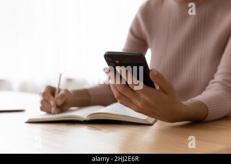 Les femmes recherchent des informations sur Internet les écrit dans le bloc-notes Banque D'Images