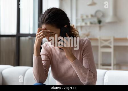 Femme hispanique parlant au téléphone avoir une conversation désagréable se sent stressée Banque D'Images