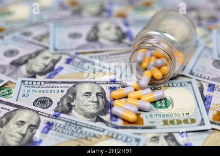 Pilules en capsules dispersées d'une bouteille sur la devise des États-Unis.Concept de soins de santé aux Etats-Unis, industrie pharmaceutique, prix des médicaments, pharmacie Banque D'Images