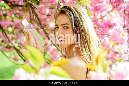 Belle femme avec de l'eau micellaire.Tonique du visage.Eau de nettoyage.Produits de soins pour la peau.Démaquillant. Banque D'Images