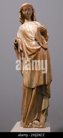 Vierge debout et enfant ca.1270–80 Français du Nord portant une couronne, Marie tenait à l'origine le bébé Jésus, maintenant disparu.La surface usée suggère que cette image dévotionnelle privée a été caressée et embrassée.L'emprise gracieuse, les proportions élevées et les plis élégants relient la figure à la sculpture monumentale produite dans le nord de la France.Vierge debout et enfant 464054 Nord Français, Vierge debout et enfant, env.1270?80, Ivoire, hors tout : 10 1/2 x 3 1/16 x 1 13/16 po.(26,7 x 7,8 x 4,6 cm).Metropolitan Museum of Art, New York.Don de J. Pierpont Morgan, 1917 (17.190.165) Banque D'Images