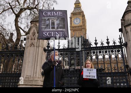 Les manifestants se tiennent devant le Parlement avec un écriteau représentant 10 Downing Street comme une « scène de crime » et un écriteau anti-Boris Johnson, pendant la manifestation.Les manifestants se sont rassemblés face au Parlement britannique alors que Boris Johnson était confronté aux questions du Premier ministre (PMQ) dans le scandale « Partygate » Banque D'Images
