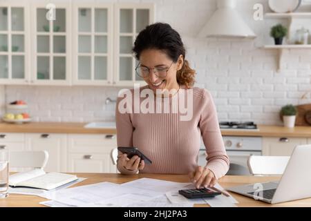 Woman effectue des calculs et paie des factures via l'application e-Bank sur smartphone Banque D'Images