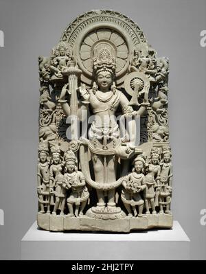 Vishnu 10th–11th siècle Inde (Punjab) cette stela élaborée du dieu Vishnu le montre au centre avec ses attributs habituels (dans le sens des aiguilles d'une montre en partant du haut à droite) : un chakra (discus de guerre), une trompette de conch-shell et un gada (mace).Sa main levée est tenue dans l'abhayamudra, ou le geste de peur-apaisant.Il porte un grand onglet et une longue guirlande de fleurs.Sa tête est entourée d'un nimbus orné de bandes de pétales de lotus, de flammes et de motifs floraux triangulaires abstraits.Flanquant ses jambes sont six figures: Les personnifications de son discus et de son conch trompette (qui ont aussi ces attributs), ses deux Banque D'Images