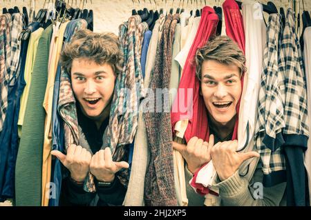 Jeunes frères hipster au marché hebdomadaire de vêtements - meilleurs amis partageant du temps libre pour s'amuser et faire du shopping dans la vieille ville en une journée ensoleillée Banque D'Images