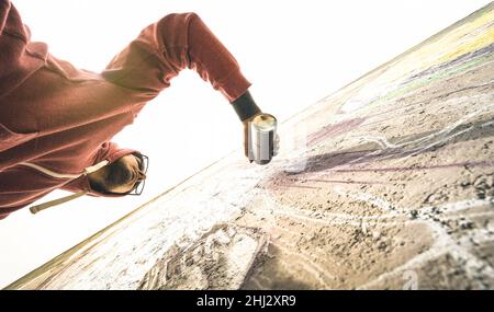 Vue inférieure de l'artiste de rue peignant des graffitis sur le mur générique - concept d'art moderne avec un homme urbain qui interprète et prépare des murales en direct Banque D'Images