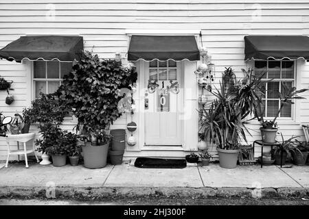 Porte avant avec marqueur de distance “0” et geckos décoratifs à Key West, Floride, FL, États-Unis.Des bouées de pêche suspendues et un auvent rouge entourent la porte. Banque D'Images