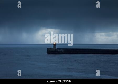 En regardant la rivière Tyne vers la mer du Nord à l'aube, alors que de grands nuages de pluie gris surgient les Piers Banque D'Images